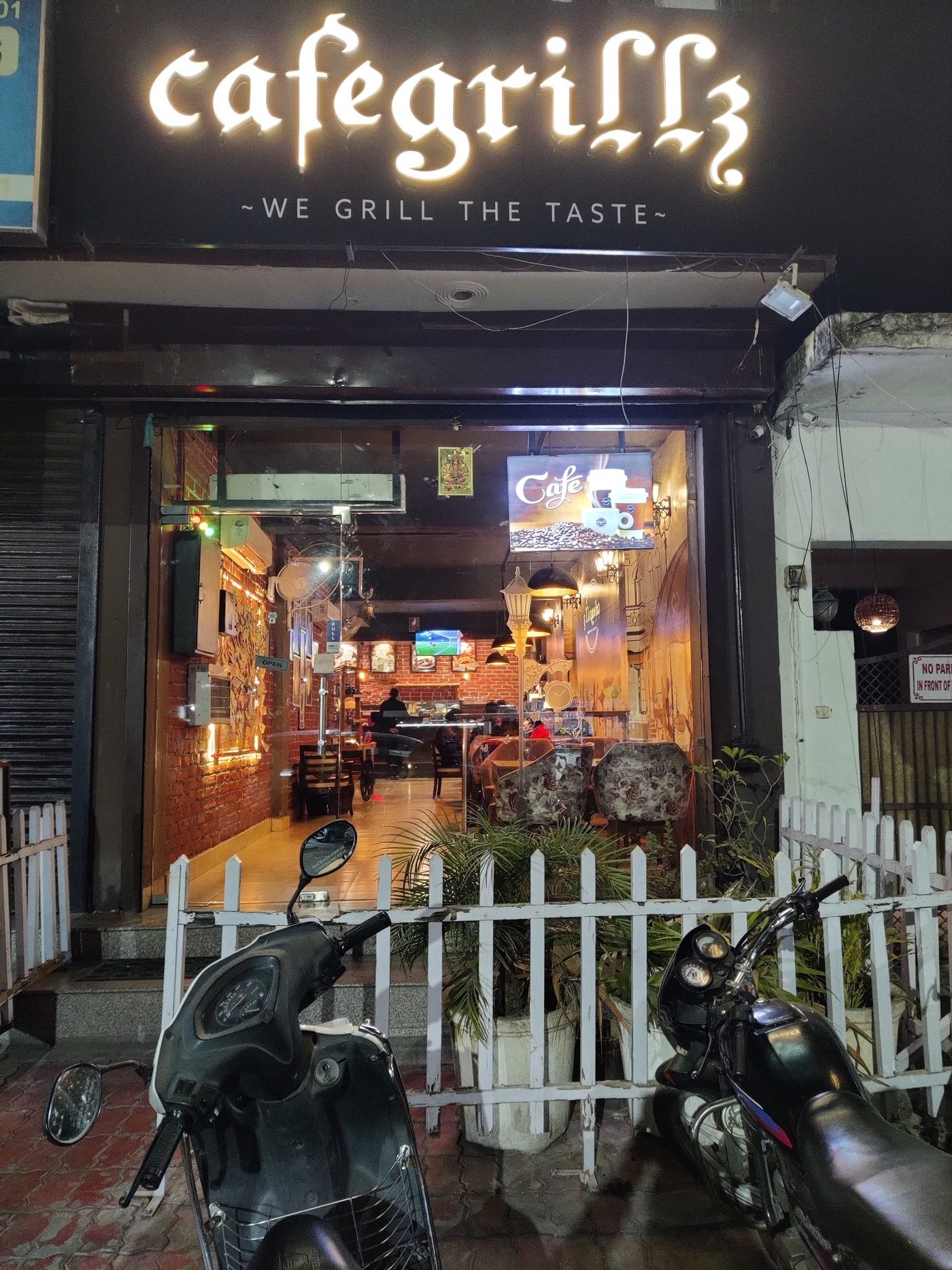 The Cafe Grillz shopfront lit up at night