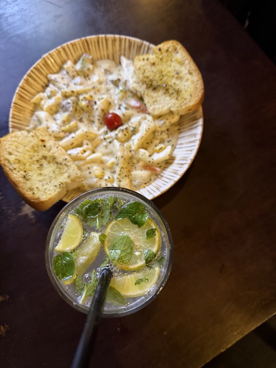 White sauce pasta with garlic bread and a mojito