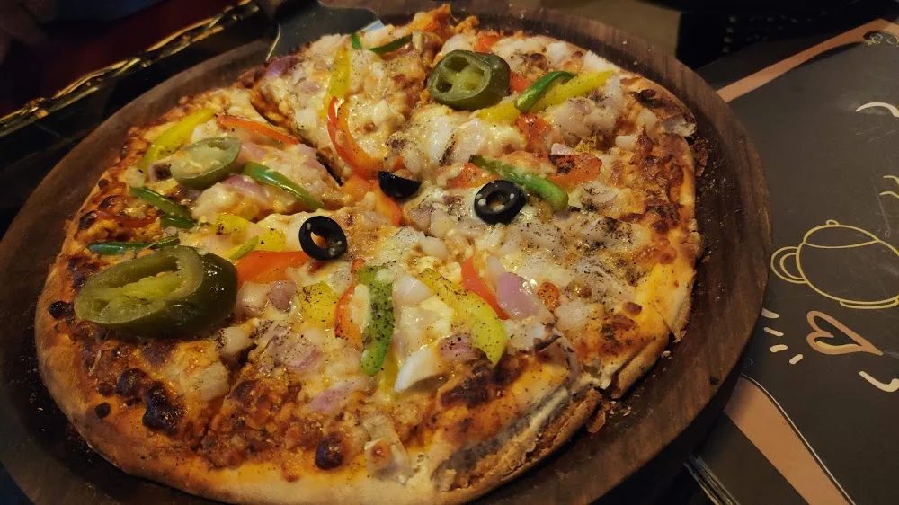 A loaded veg pizza on the wooden board